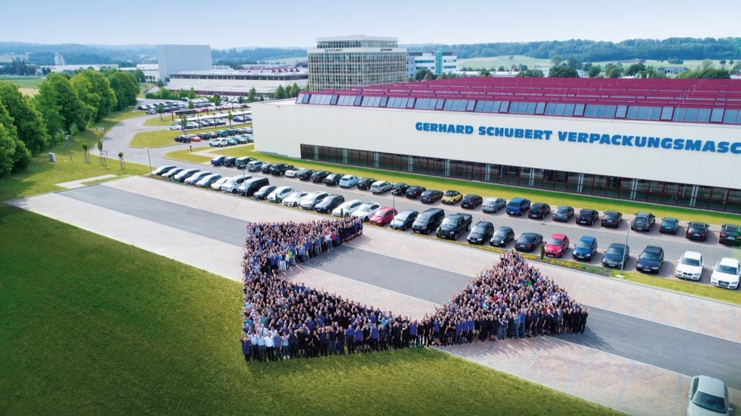 Mitarbeitende der Gerhard Schubert GmbH präsentieren das Logo